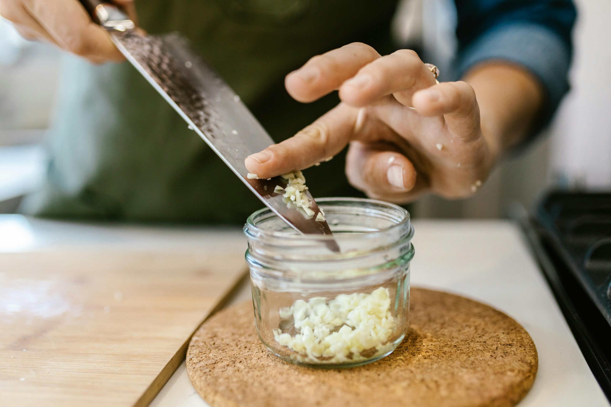 About Close-up of a woman chopping garlic on a board, capturing the cooking process.