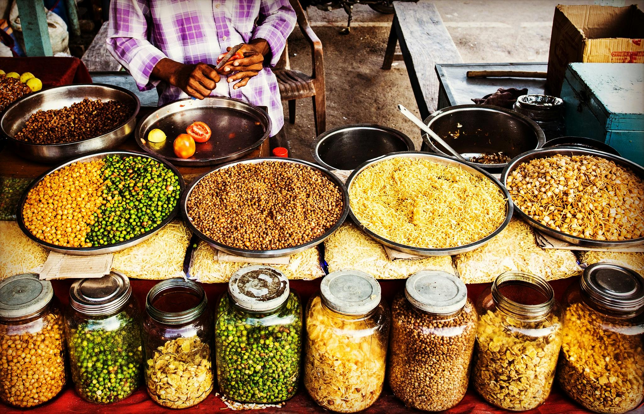 About Colorful display of spices and legumes in a traditional Indian street market.